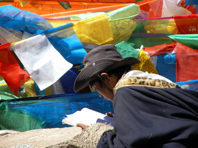 Tibetan man reading prayers at the top of the Dromala Pass. Mt. Kailash, Tibet.